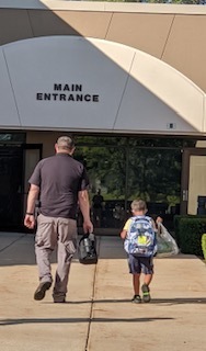 Resource Officer walking into school with student.