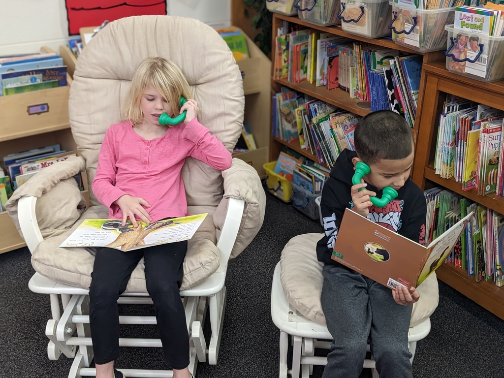 Two students reading on whisper phones